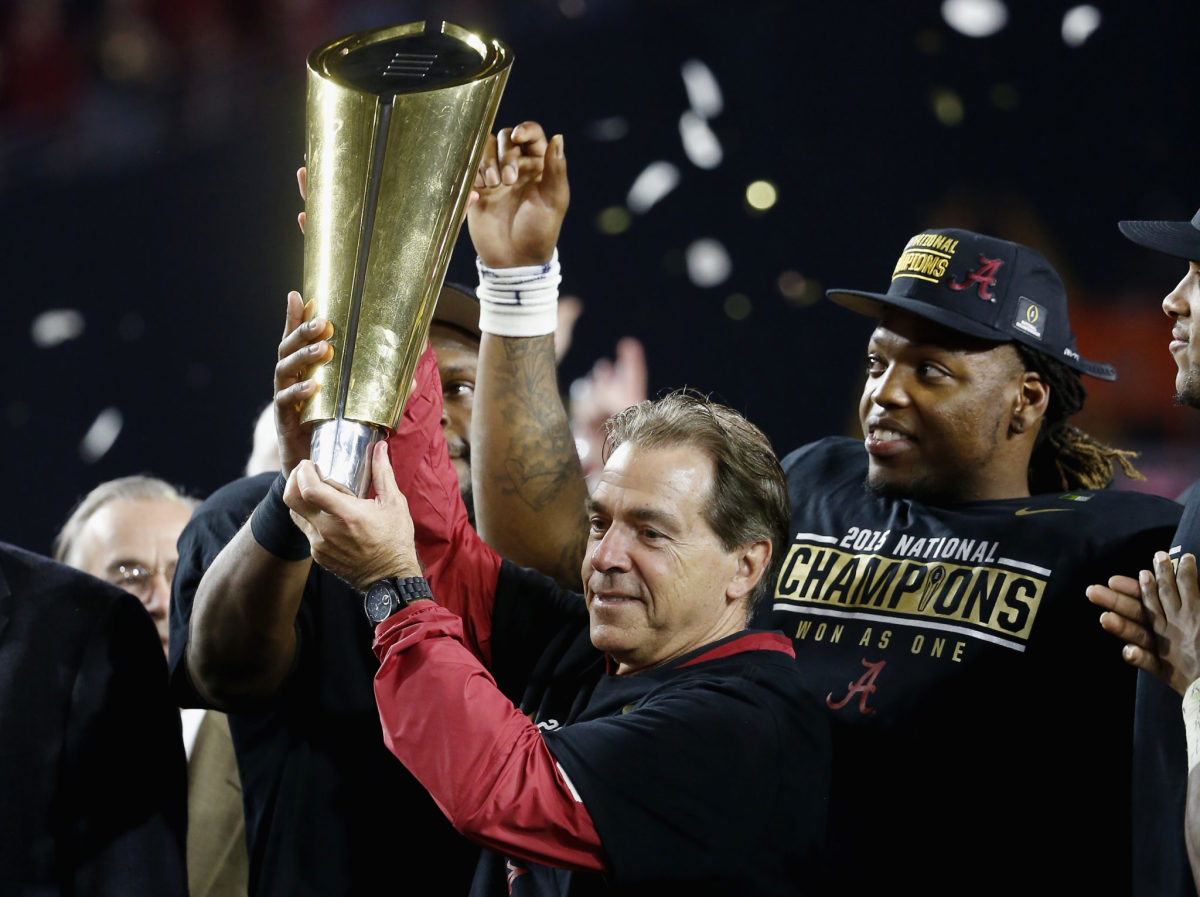 Head coach Nick Saban of the Alabama Crimson Tide celebrates by hoisting the College Football Playoff National Championship Trophy after defeating the Clemson Tigers in the 2016 College Football Playoff National Championship Game.