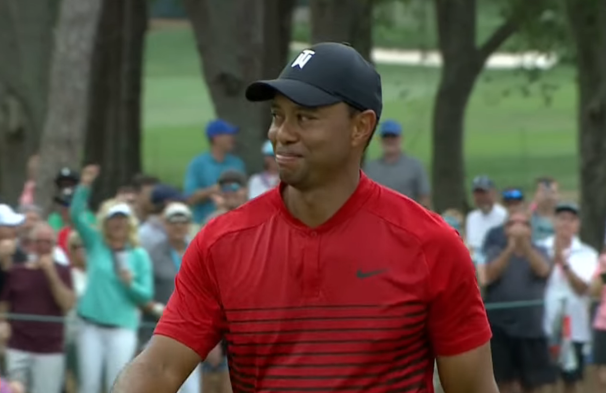 Tiger Woods smiles after drilling a put.