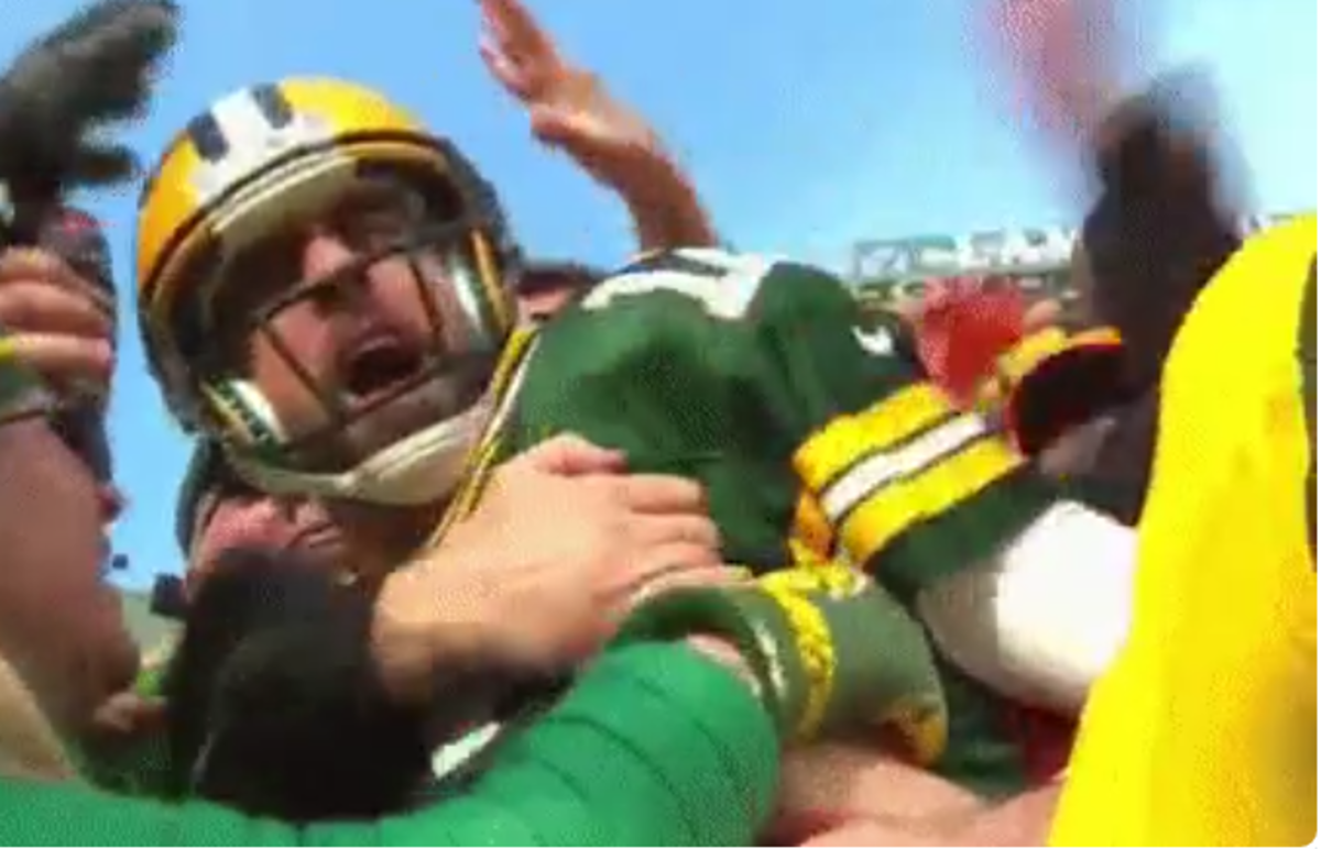 Aaron Rodgers does the "Lambeau Leap" after a touchdown.