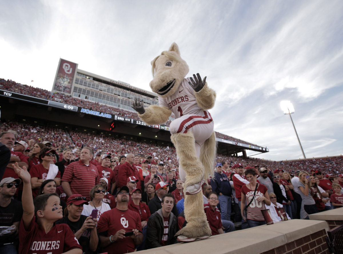 Oklahoma's mascot dancing in front of fans.