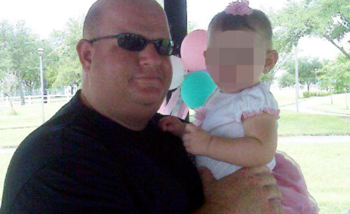 Aaron Feis holding a baby.