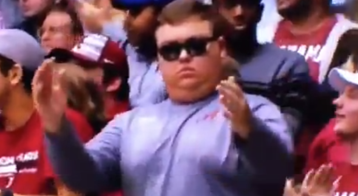 An Alabama fan claps in the stands.
