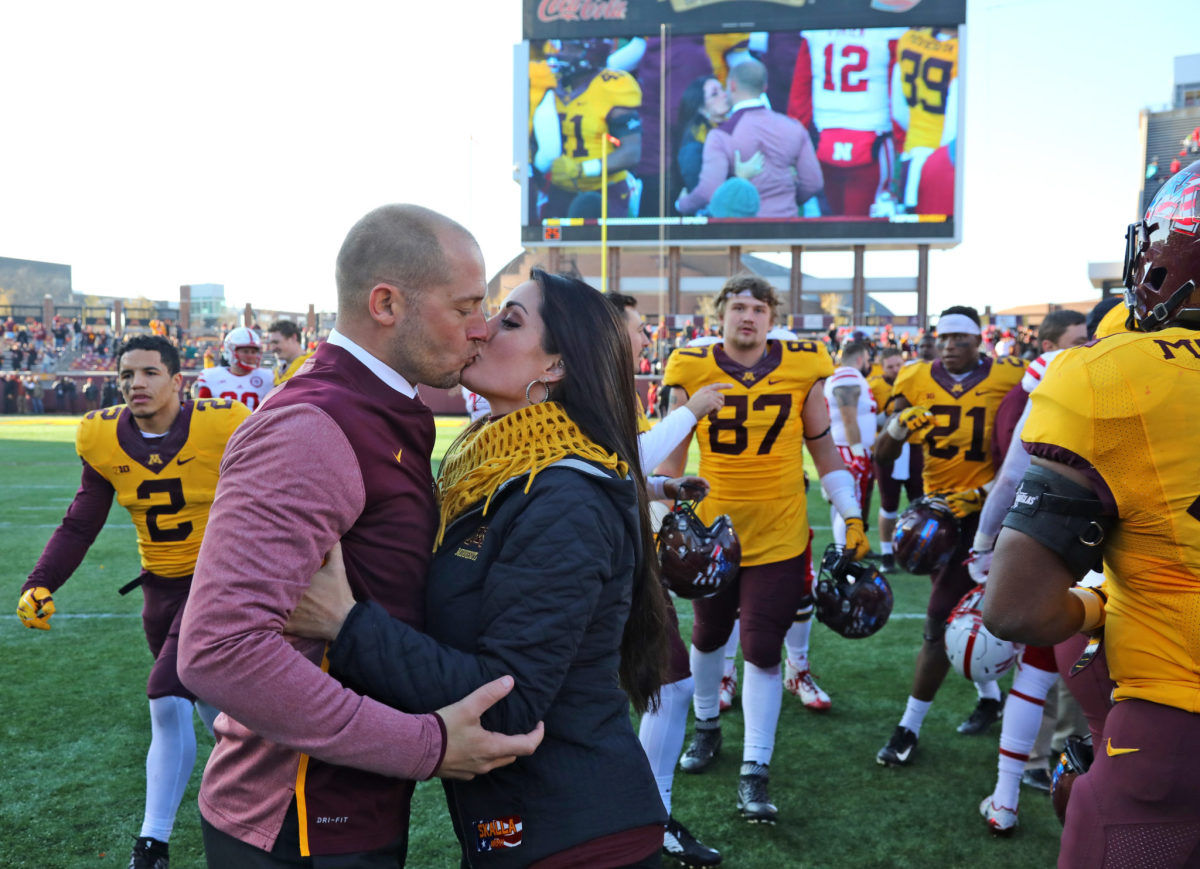 PJ Fleck and his wife kiss.