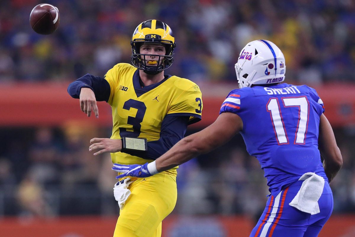 Wilton Speight of the Michigan Wolverines throws the ball under pressure from Jordan Sherit #17 of the Florida Gators.