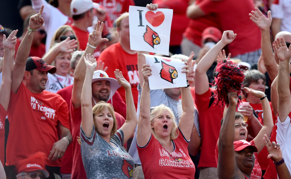 Louisville fans in the stands react to a touchdown.