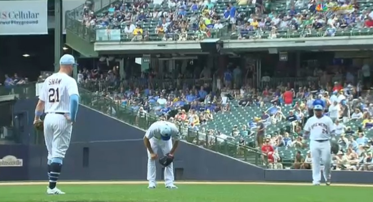 Brewers pitcher Adrian Houser throws up on the mound.