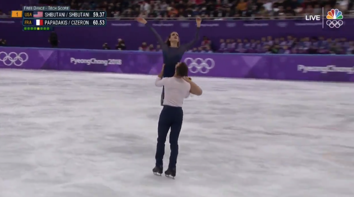 An ice skater picks up his partner.