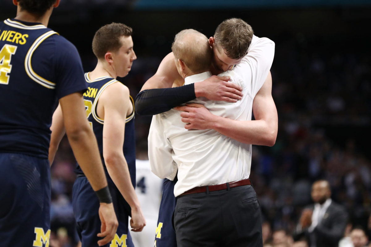 Head coach John Beilein hugs Moe Wagner of the Michigan Wolverines as he comes off the court late in the second half against the Villanova Wildcats.