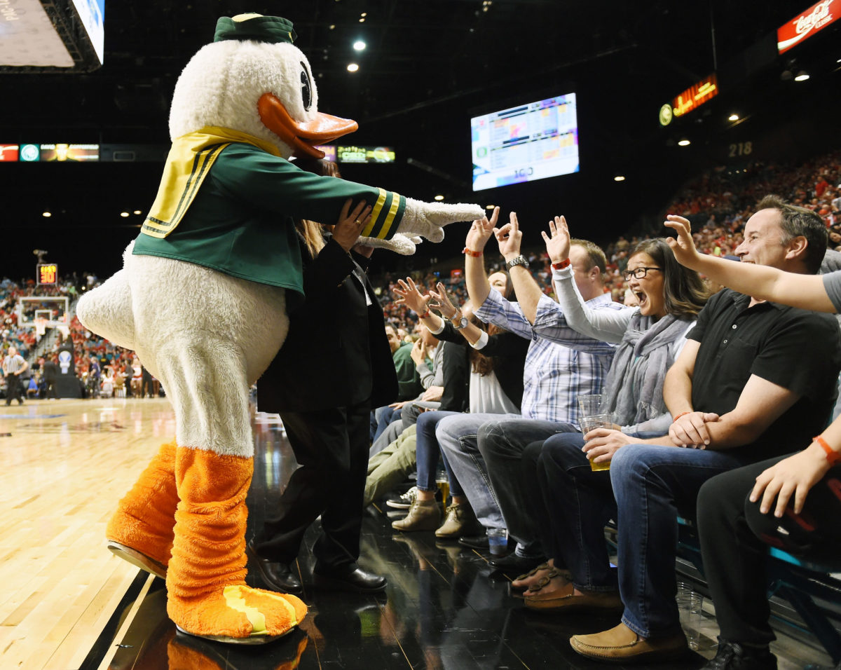 Oregon's mascot high-fives fans during a basketball game.