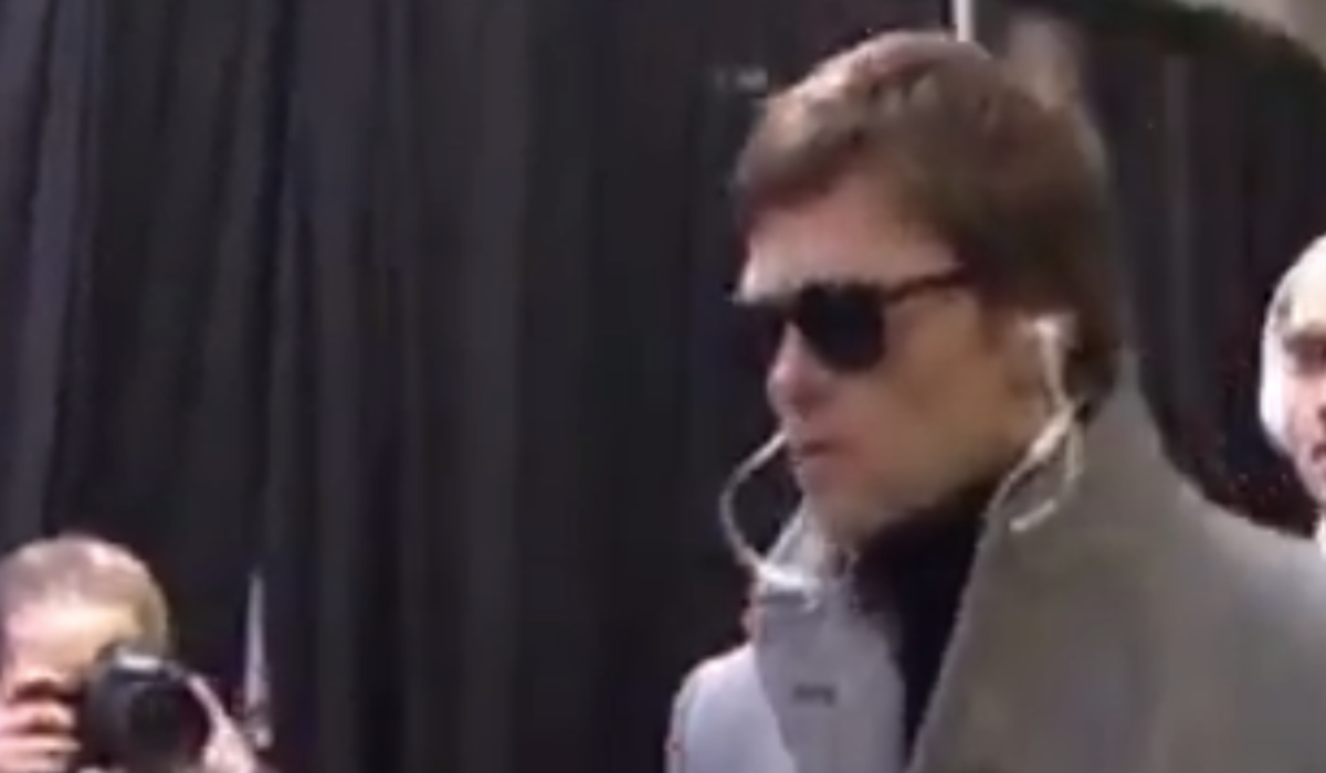Tom Brady walking with sunglasses on.