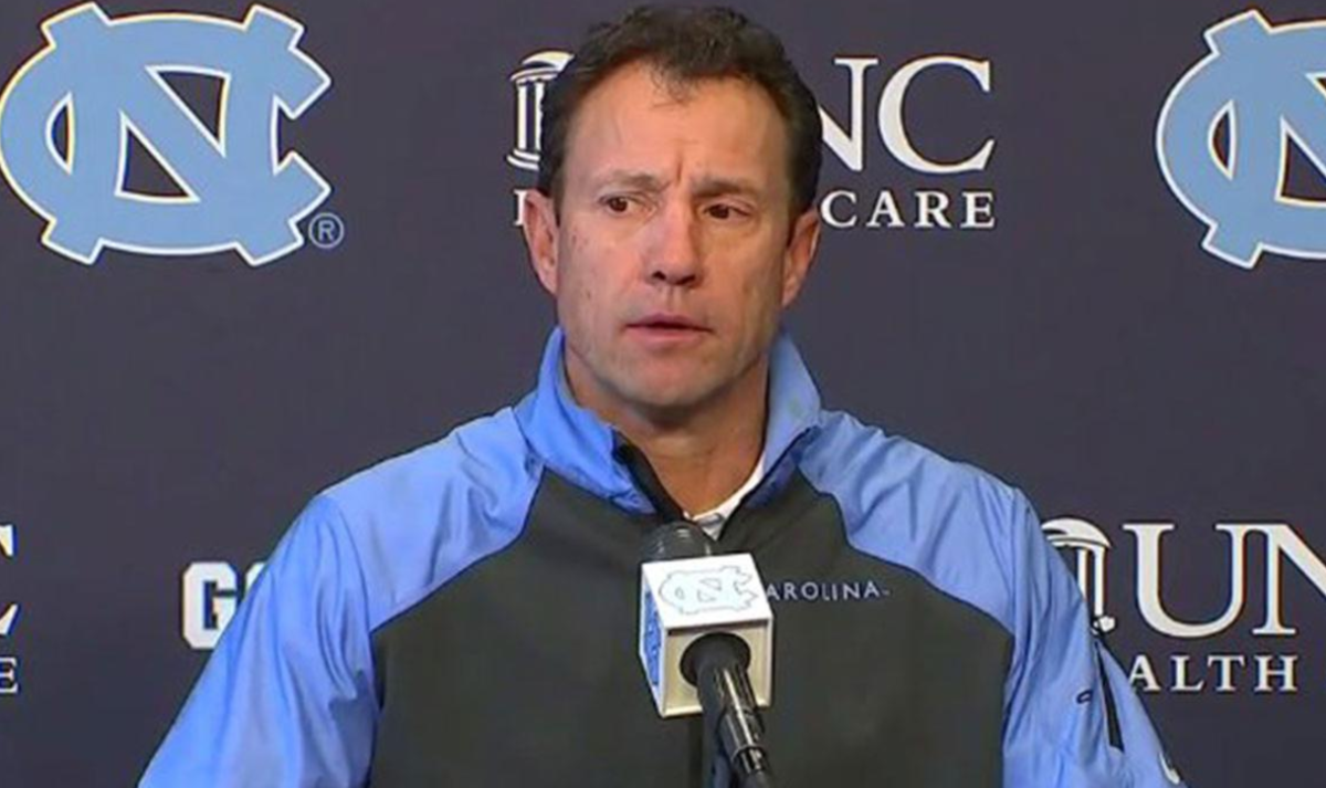 Larry Fedora speaks at the podium after a UNC game.