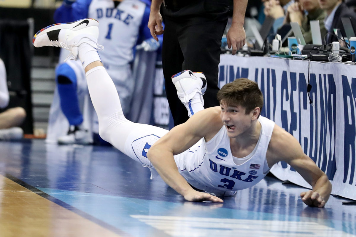 Grayson Allen slides out of bounds after saving the ball.
