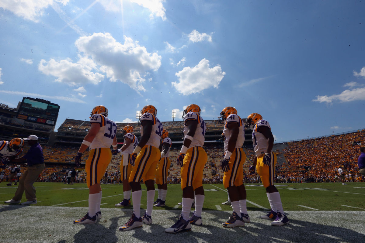 LSU players on the sideline warming up for a game.