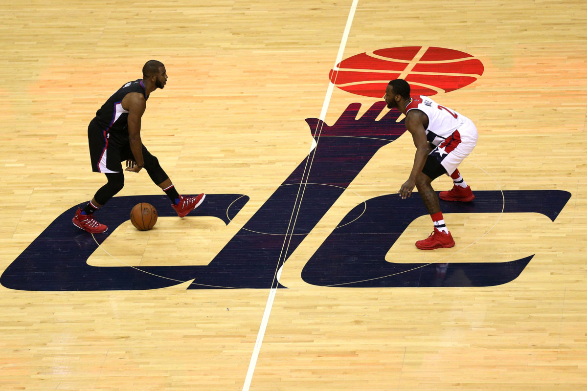 Chris Paul being guarded by John Wall while dribbling at midcourt.