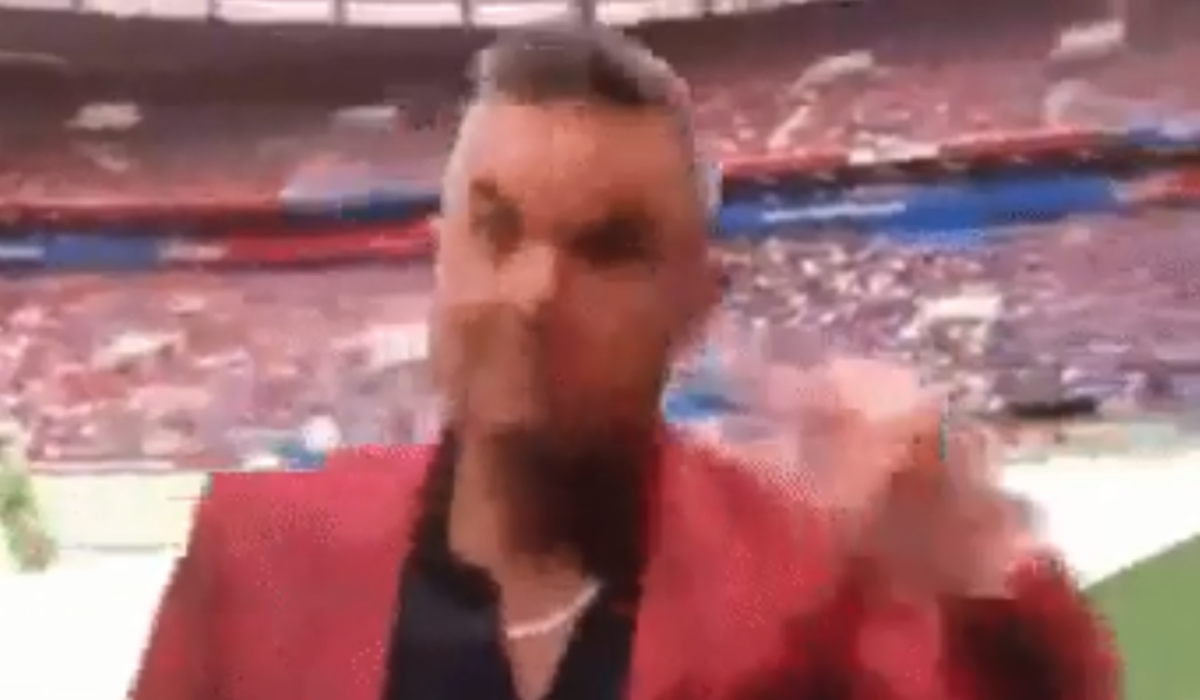 Robbie Williams flips off the camera.