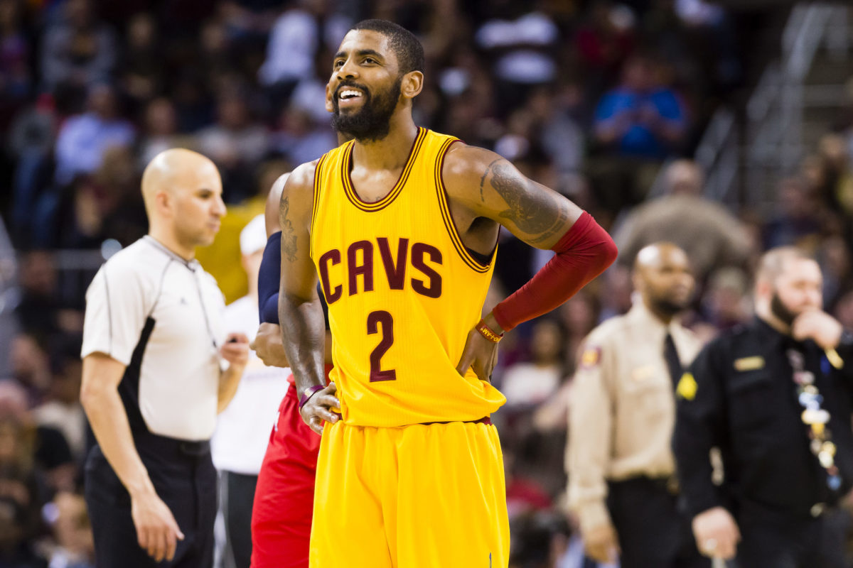 Kyrie Irving smiling in his Cleveland Cavaliers uniform.