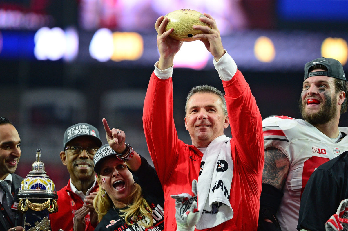 Urban Meyer holding up the Fiesta Bowl trophy.
