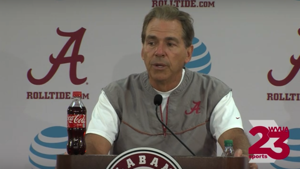 Nick Saban addresses the media with a bottle of coke.