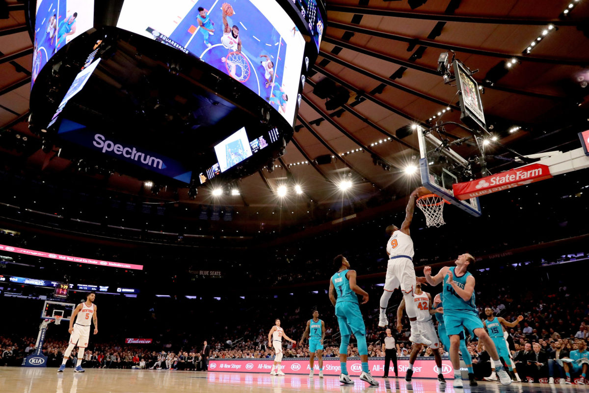 A Knicks player dunks the ball.
