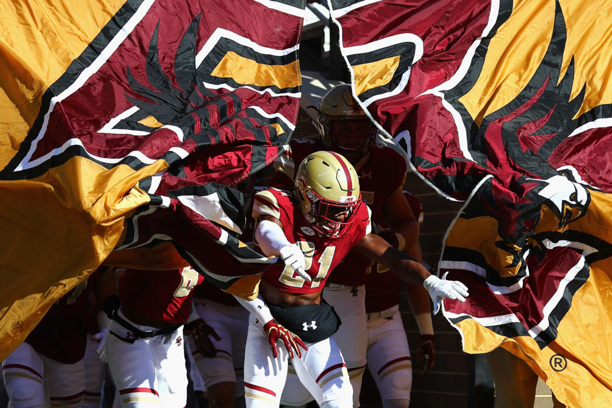 Boston College football players running onto the field.