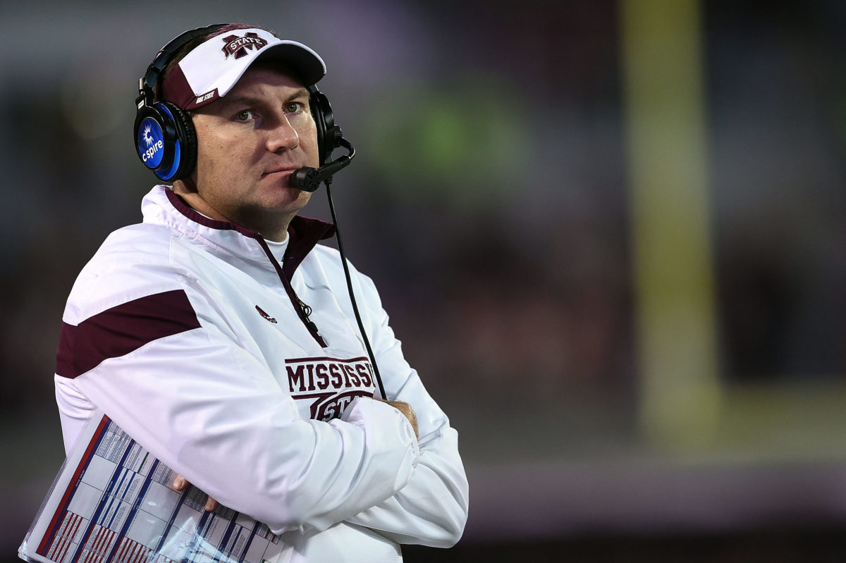 A closeup of Dan Mullen wearing a headset on Mississippi State's sideline.