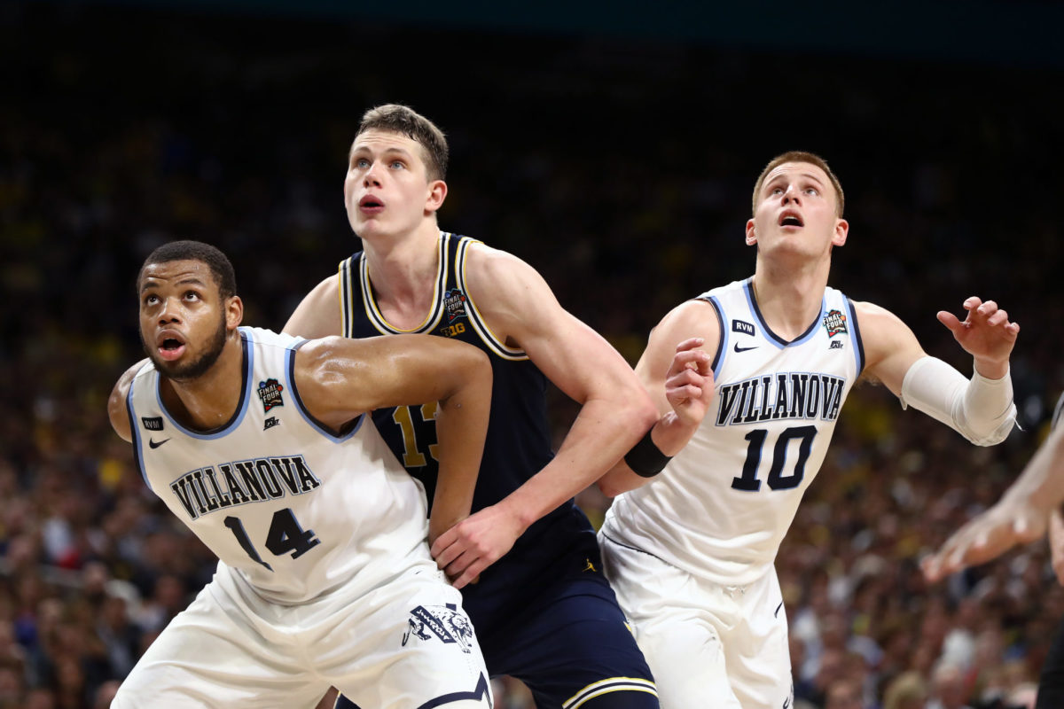 Moe Wagner being boxed out by Omari Spellman and Donte DiVincenzo.