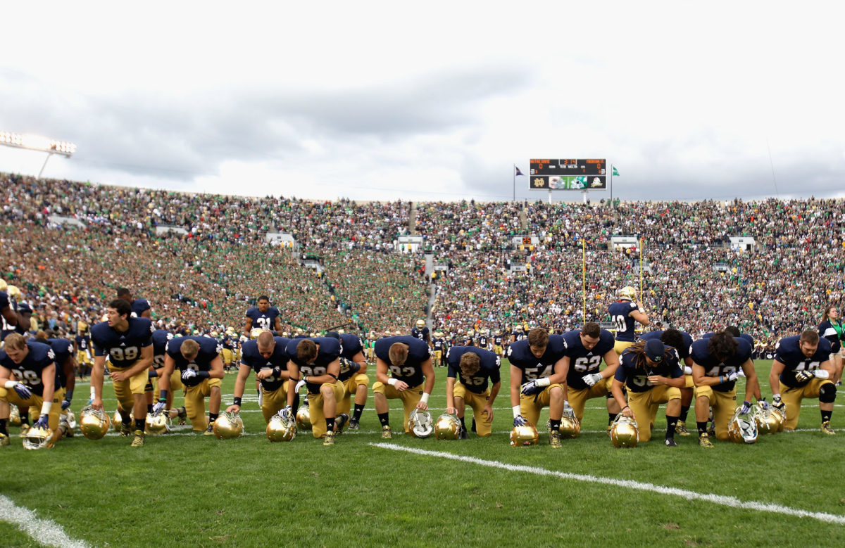 Notre Dame players kneeling in the end zone.