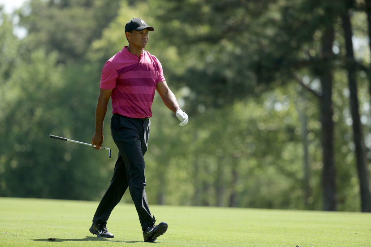 Tiger Woods walking with his club in his hand.