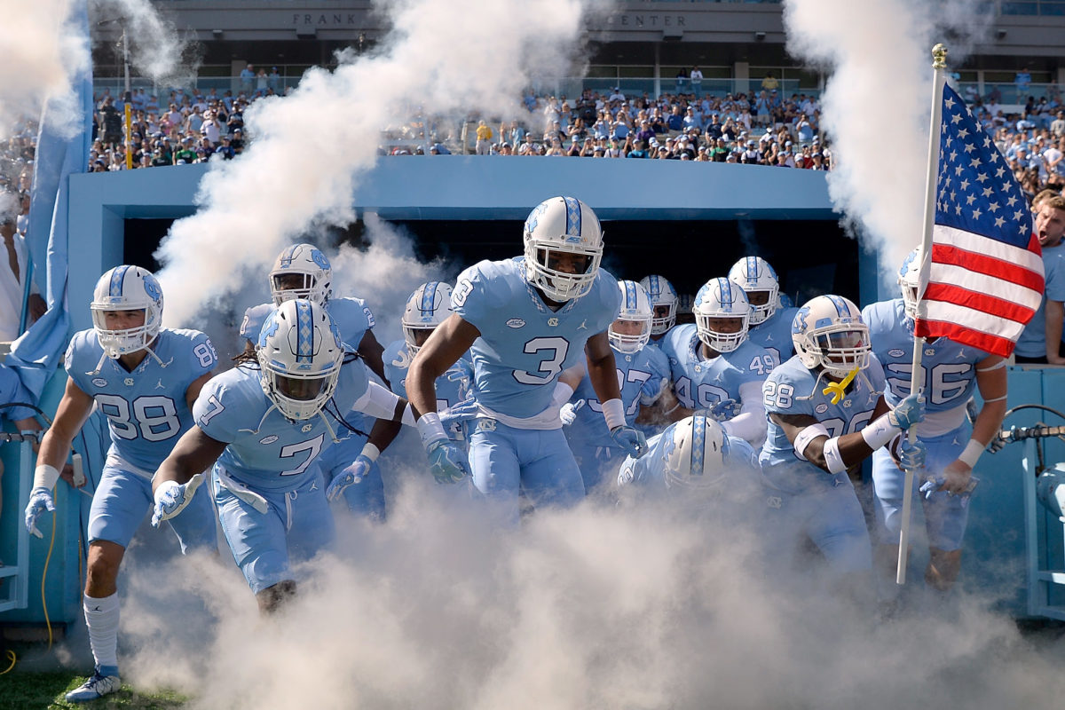 North Carolina football players run out of the tunnel.