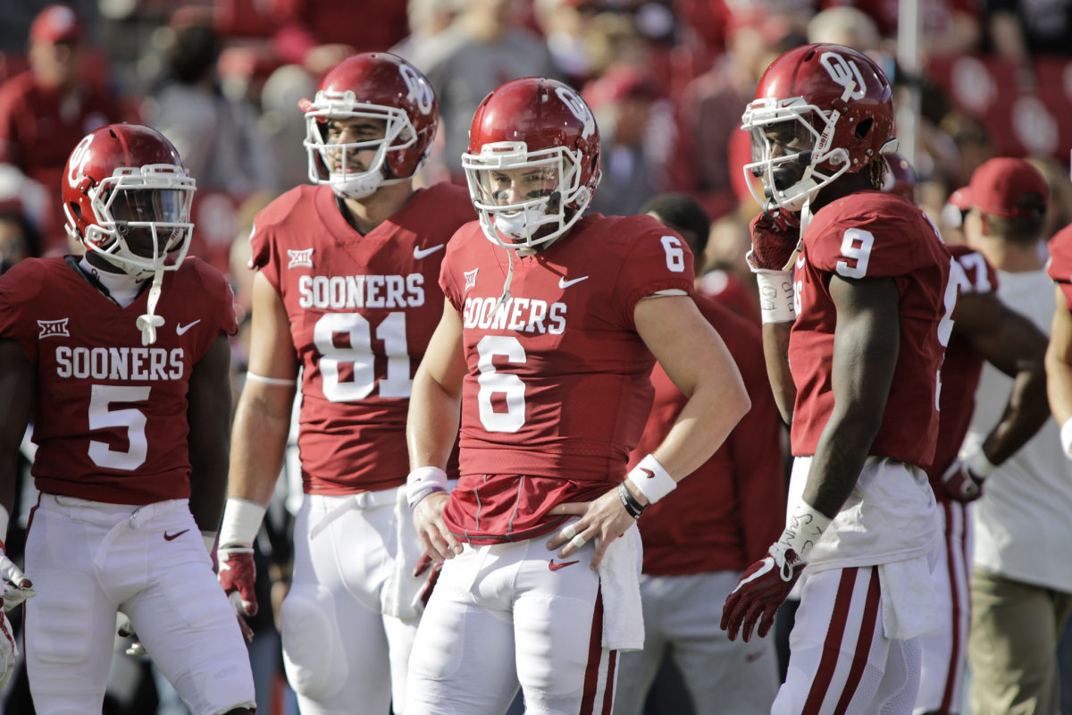 Baker Mayfield standing with his Oklahoma teammates.