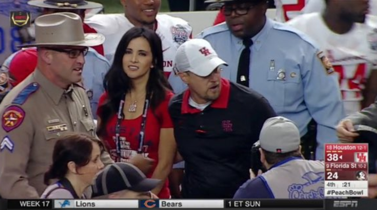 Tom Herman walking off the field with his wife.