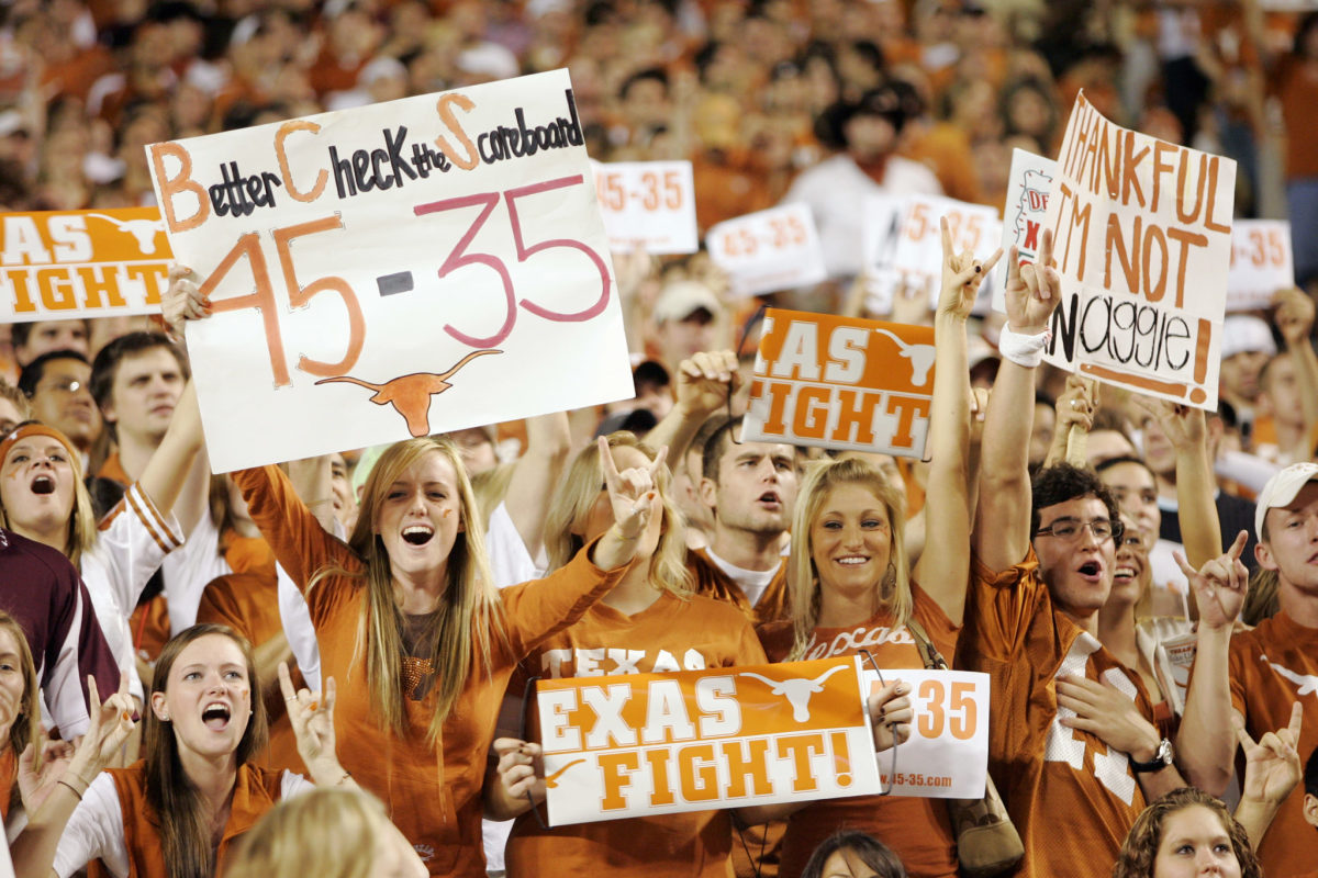 Texas Longhorns fans holding signs during a game.