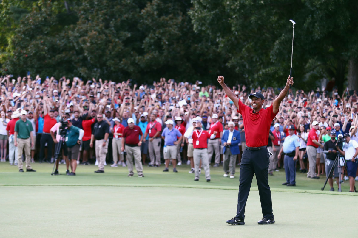 Tiger Woods raising his arms to celebrate.