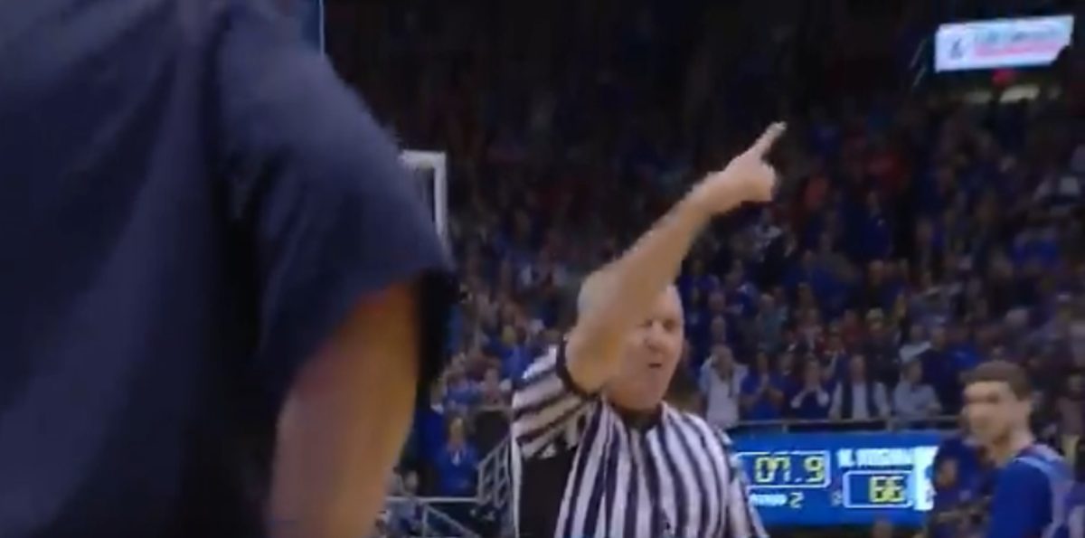 A college basketball referee pointing.