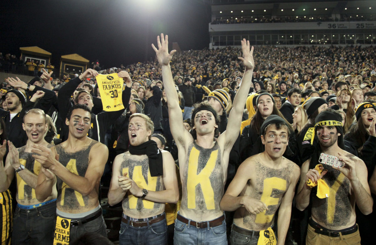 Iowa fans with painted chests.