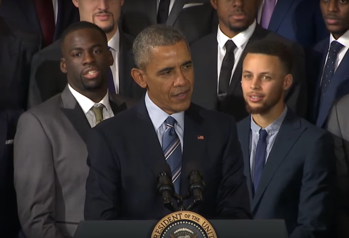 Barack Obama speaking as the Golden State Warriors watch.