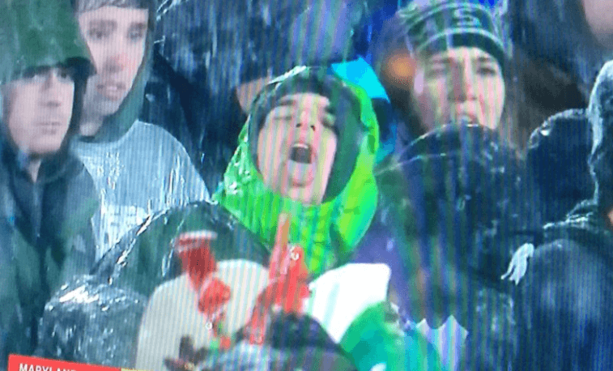 Michigan State fan catches snow on their tongue.