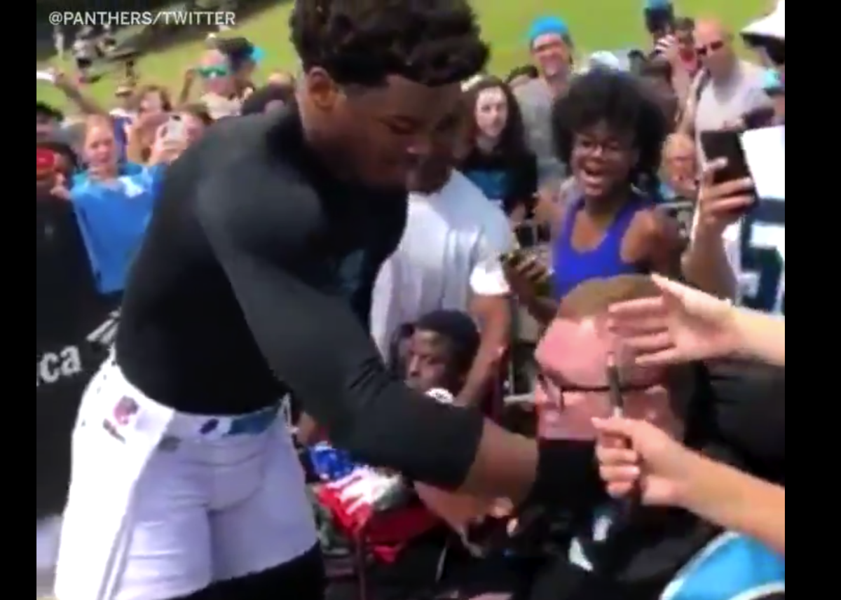 Cam Newton gives out gear to fans.