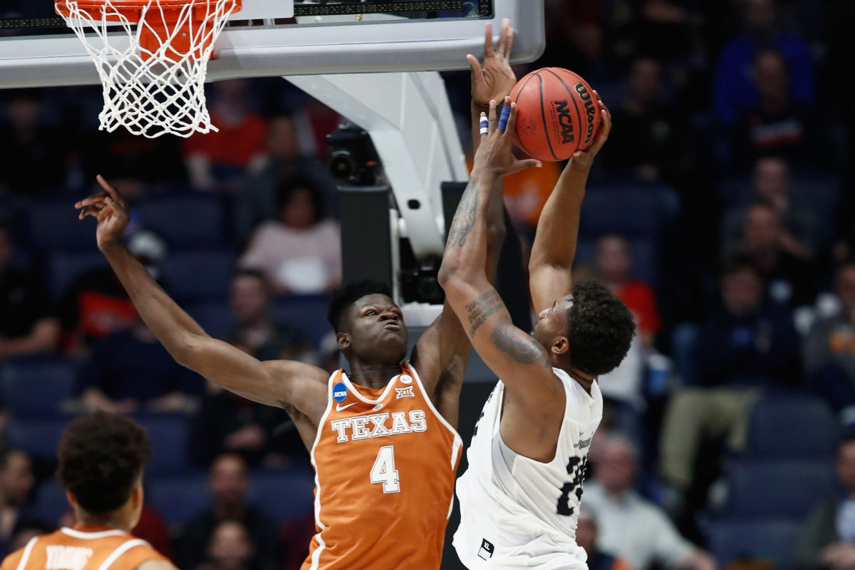 Mohamed Bamba of the Texas Longhorns blocks a shot by Jordan Caroline #24 of the Nevada Wolf Pack  during the game in the first round of the 2018 NCAA Men's Basketball Tournament.