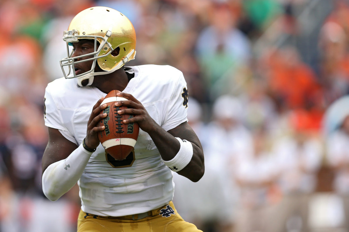 Malik Zaire dropping back for a pass in his white Notre Dame uniform.