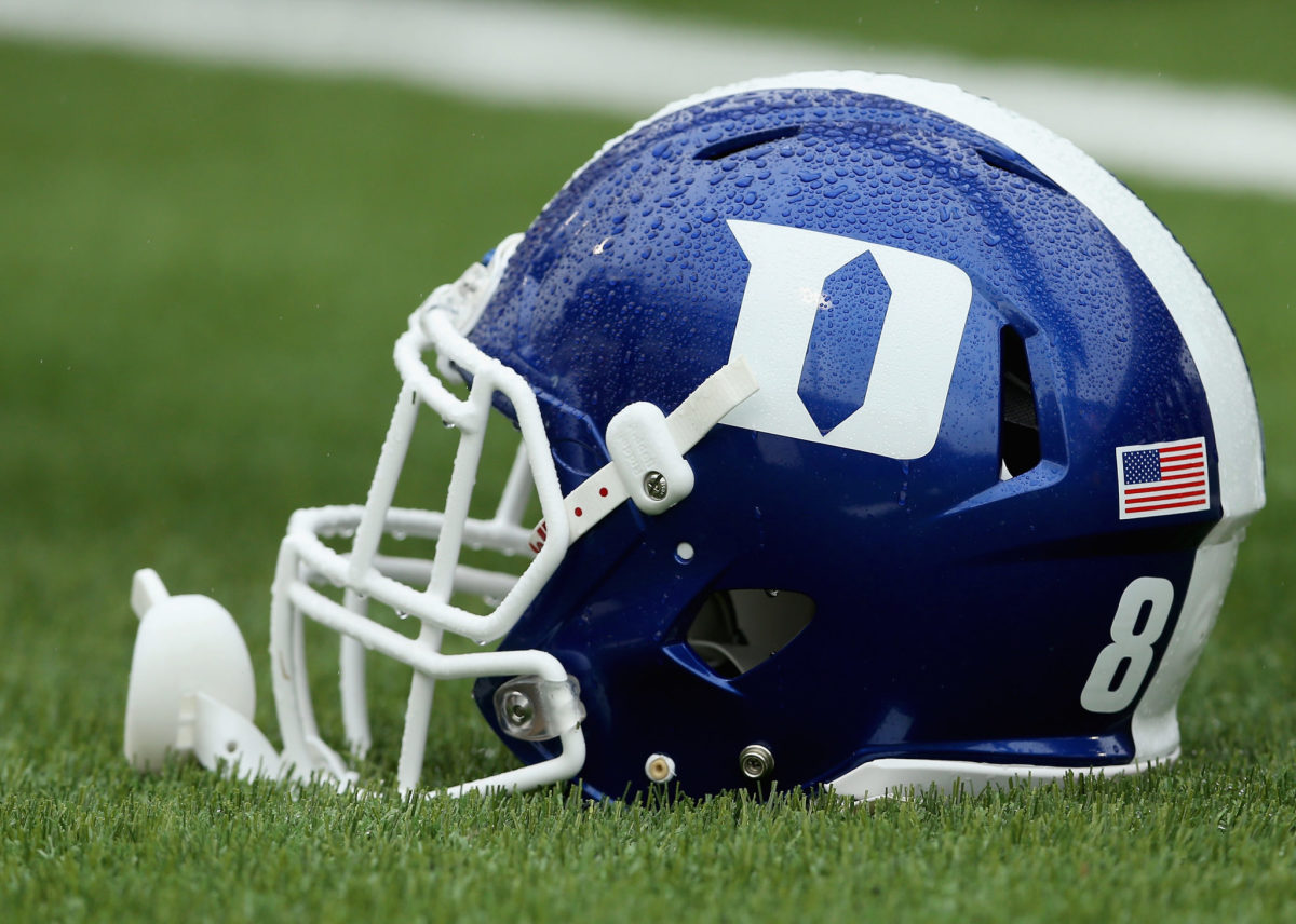 Duke helmet sits on the field during rainstorm.