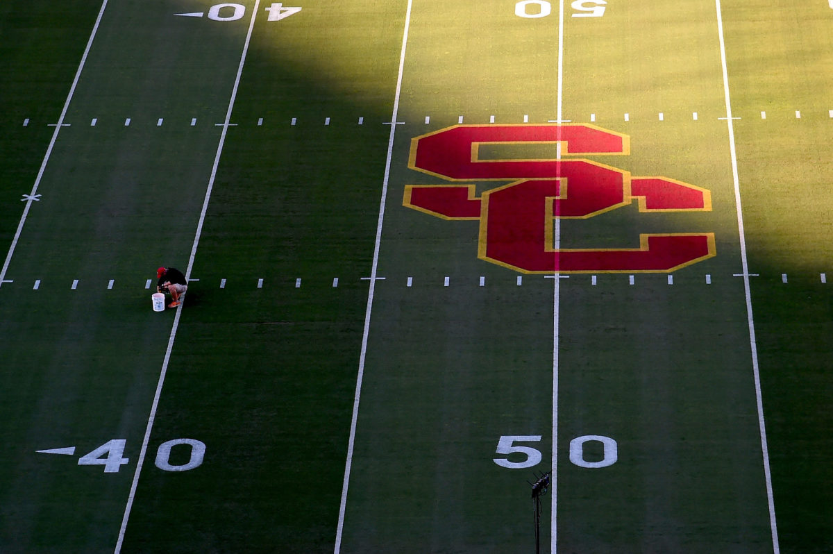 A worker painting the lines on USC's football field.