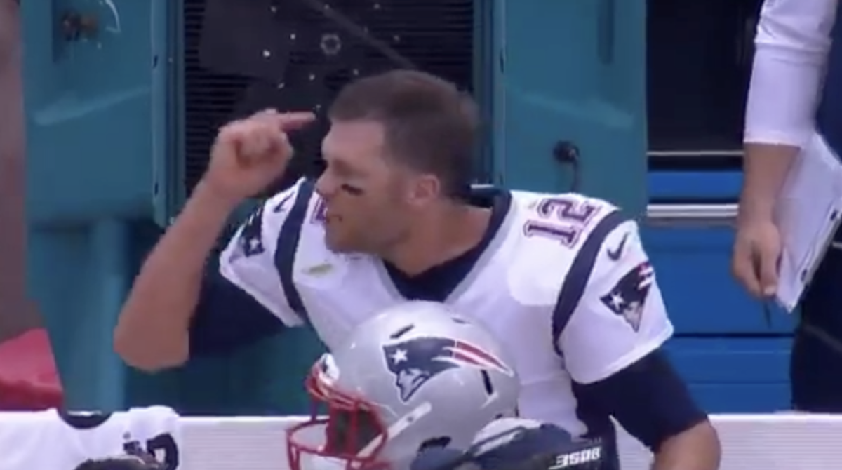 Tom Brady points to his head.