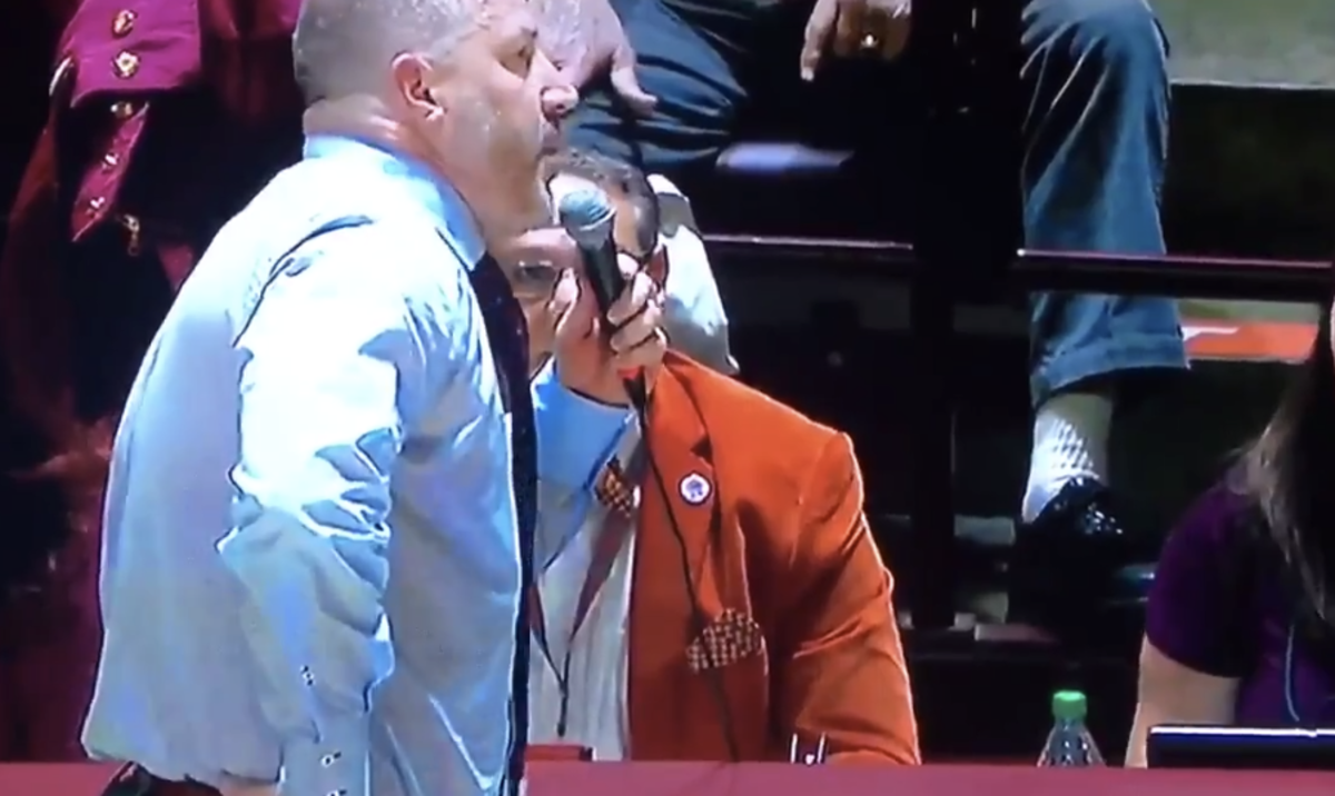 Buzz Williams speaking into a microphone.