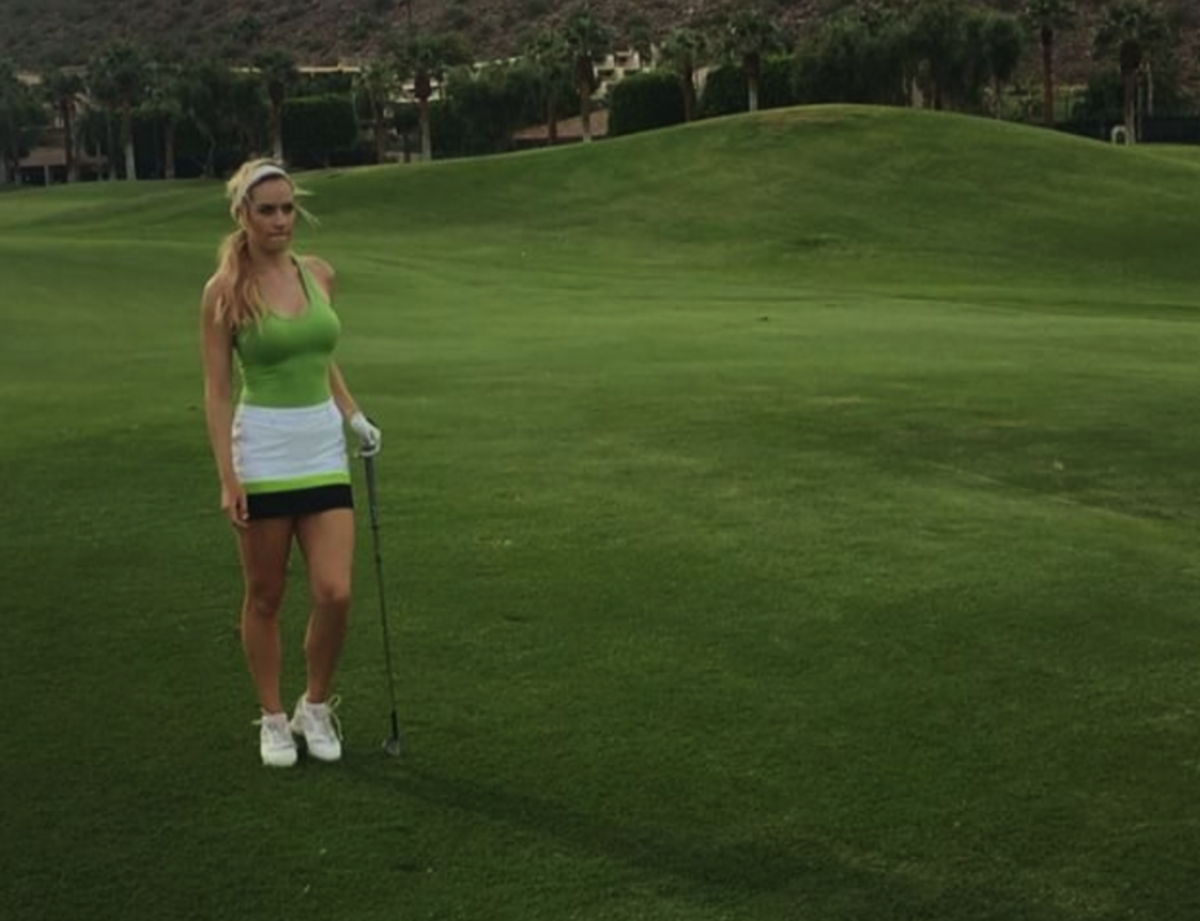 Paige Spiranac wearing a green top on a golf course.