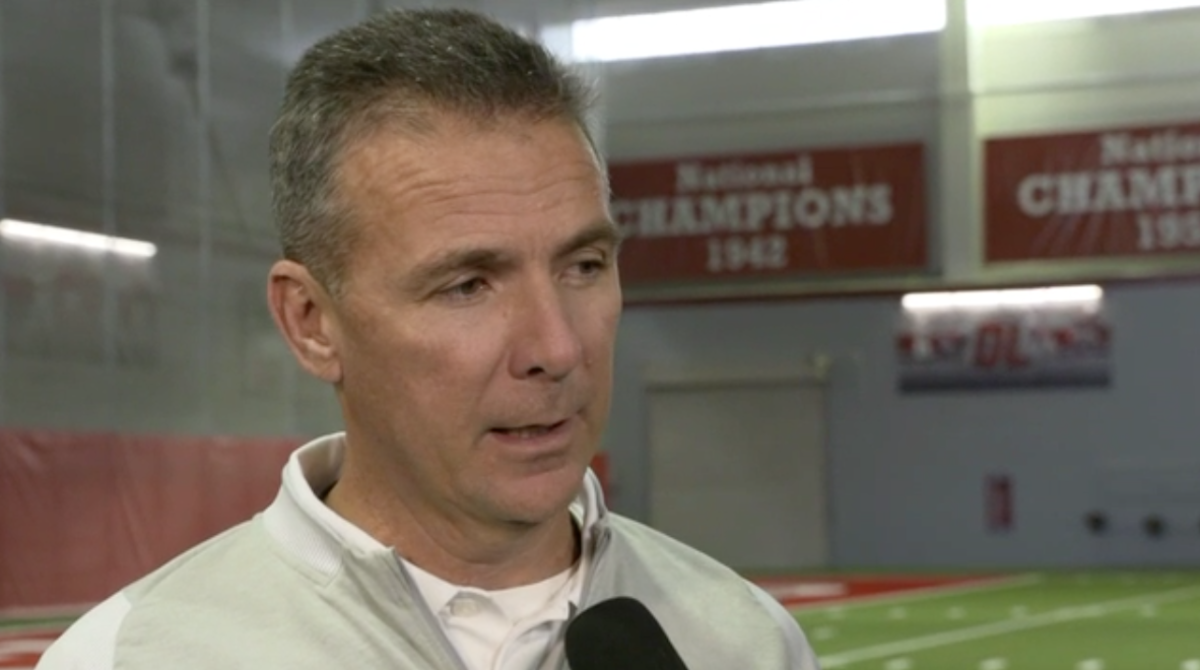 Urban Meyer speaks to a reporter in his team's facility.