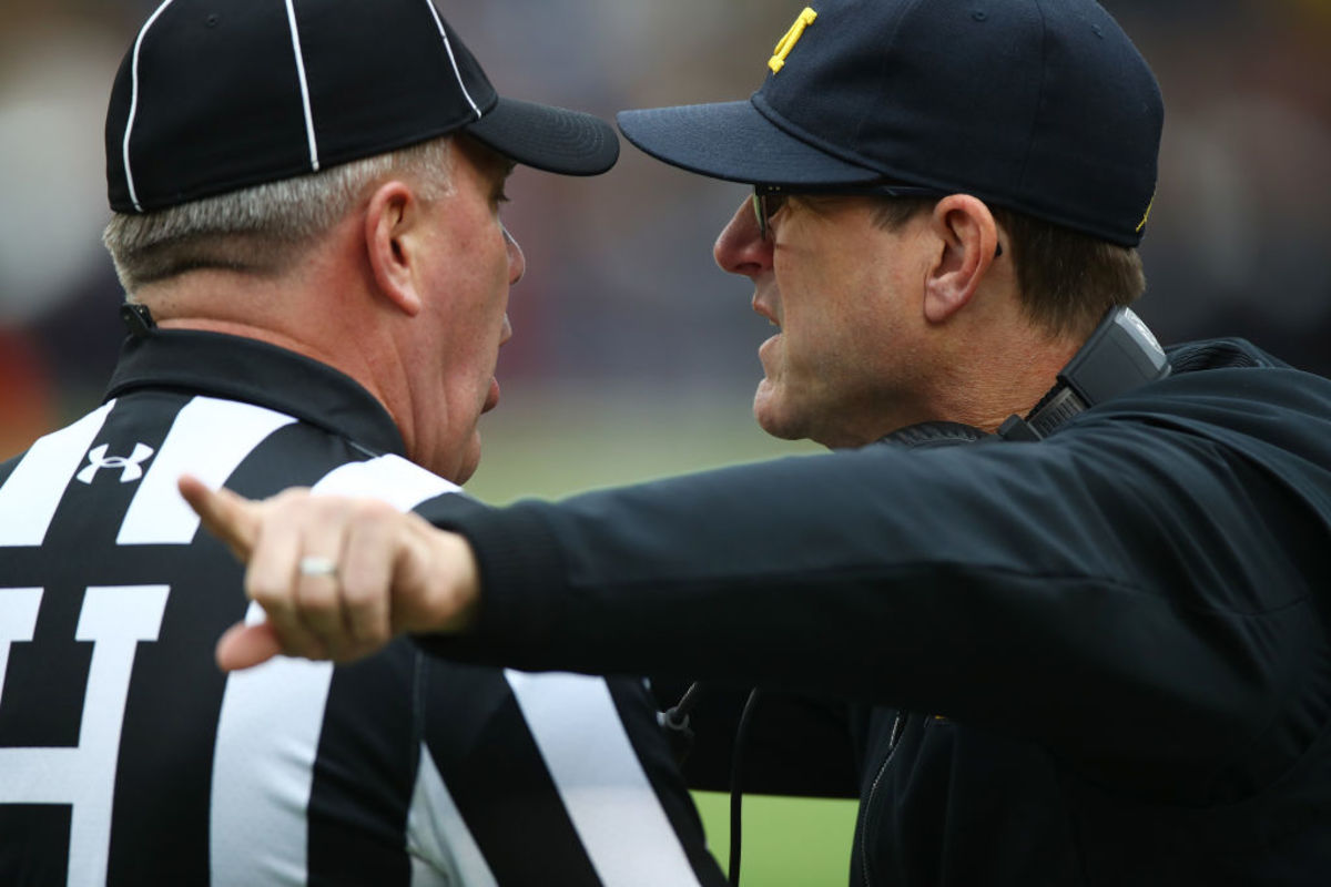 Jim Harbaugh head coach of the Michigan Wolverines talks with the referee first half against the Ohio State Buckeyes.