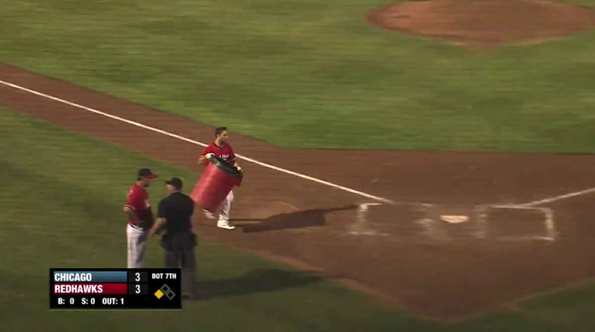 A minor league player puts a trash can behind home plate to show up an umpire.