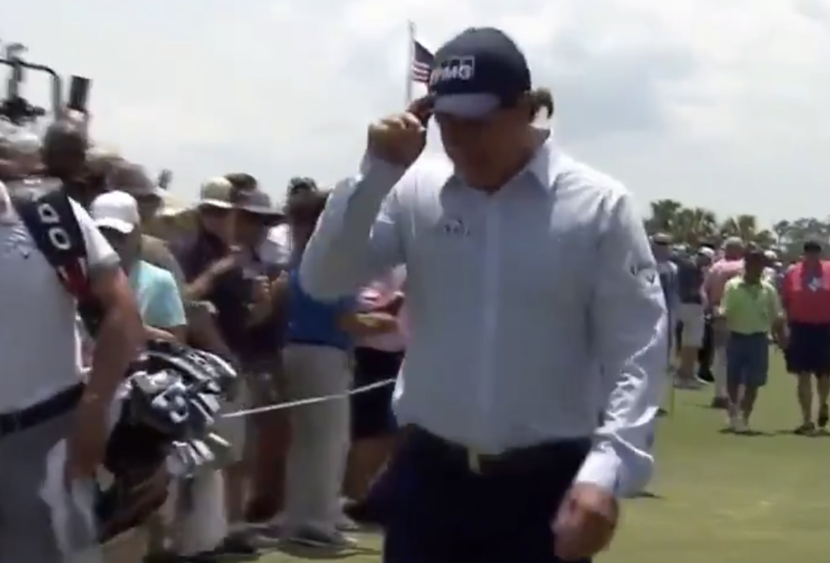 Phil Mickelon tippig his hat while walking off the course.