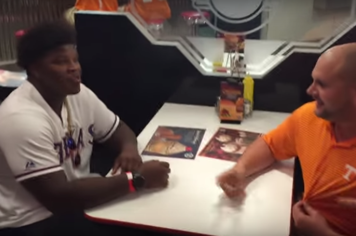 Tennessee fan arm wrestles a Florida player.